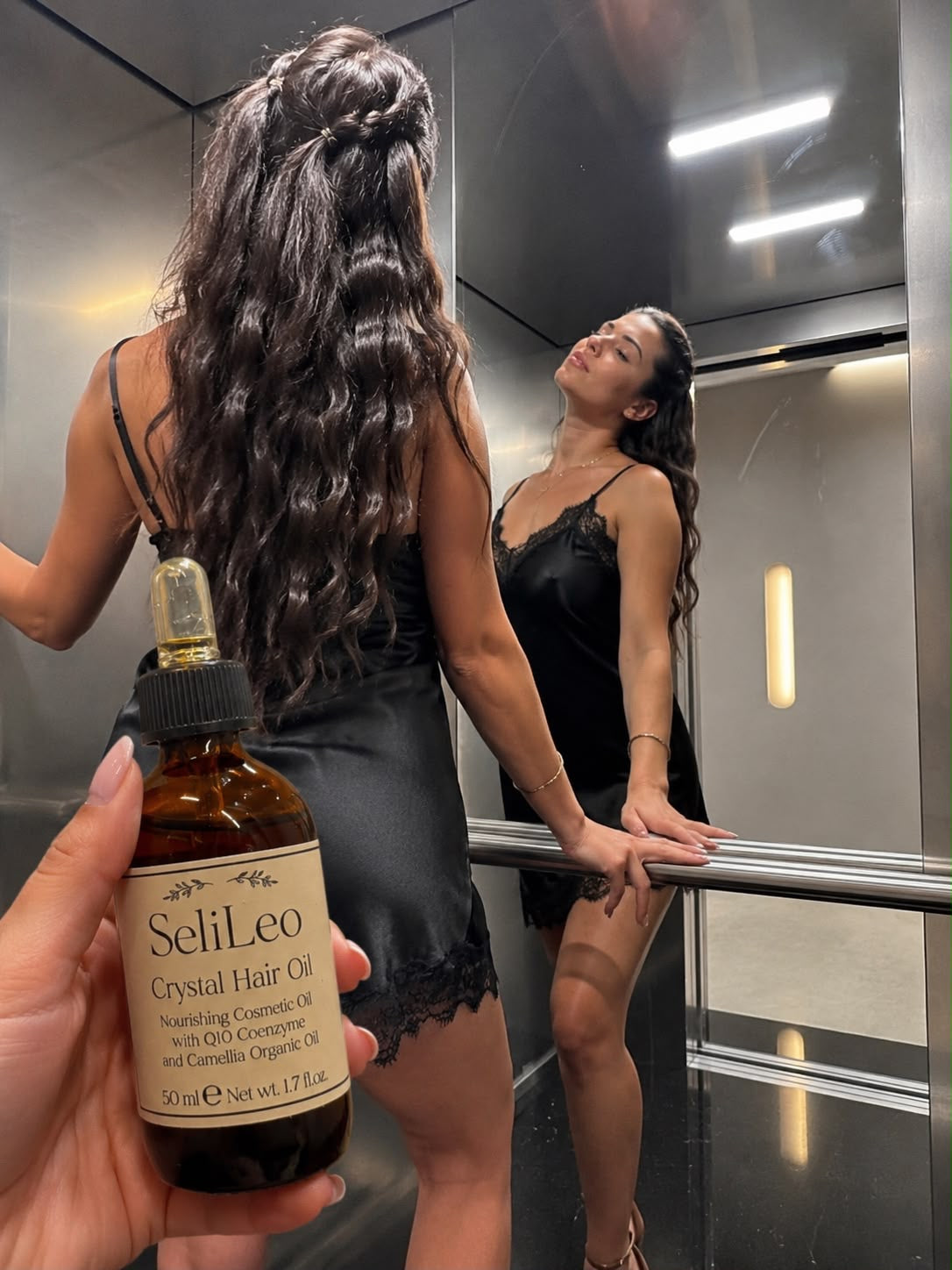 oman with long shiny hair holding SeliLeo Crystal Hair Oil
